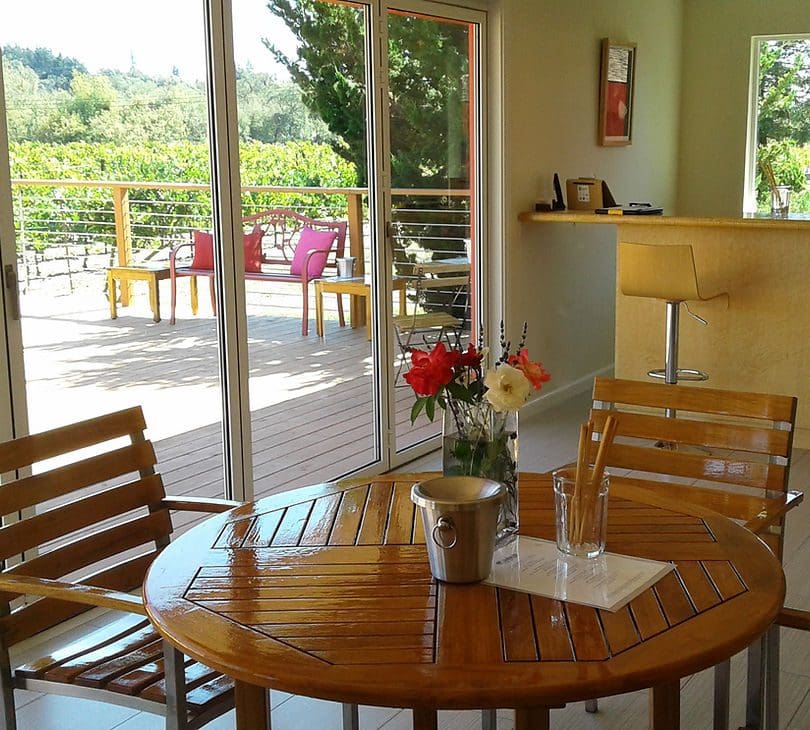 A table with flowers on it in the middle of an outdoor room.