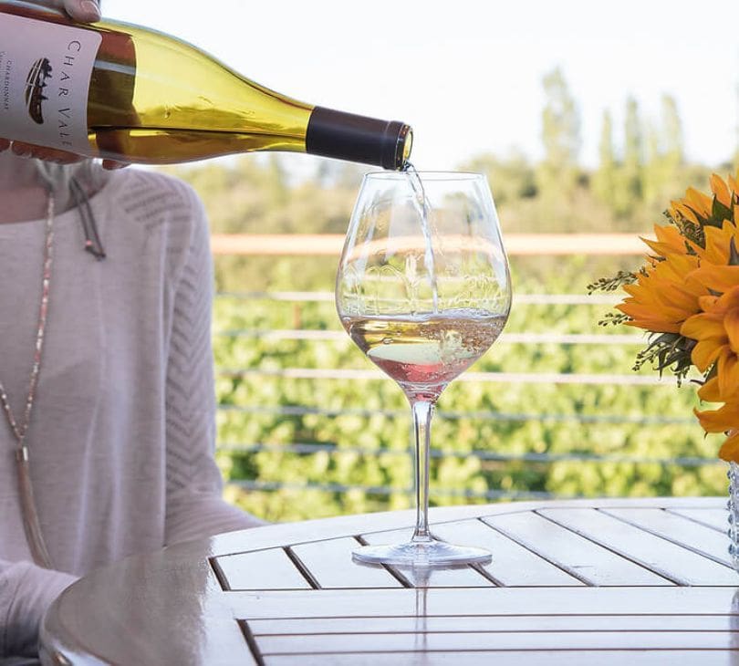 A glass of wine is being poured into the table.