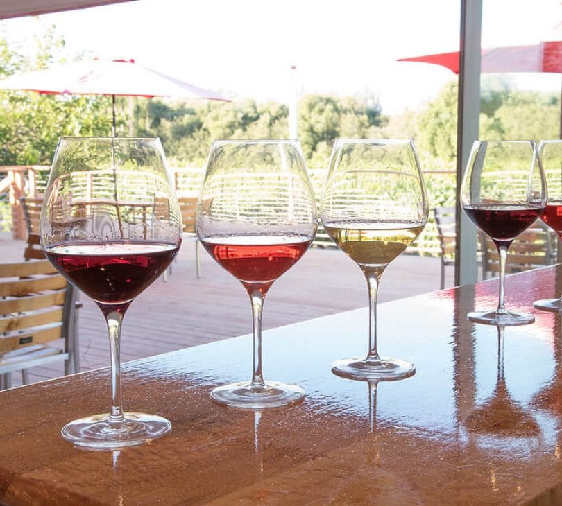 A table with four glasses of wine on it